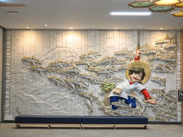 空港2階にある「釣りキチ三平」の陶板レリーフ (C)陶板レリーフ「釣りキチ三平・山魚女群泳」原画・監修：矢口髙雄