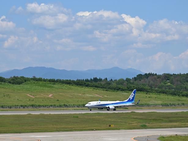 滑走路の向こうに見える「AKITA」のロゴ