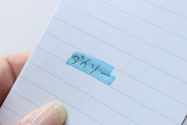 「ダイソー」の文字の上に青い蛍光ペンで線を引いた様子