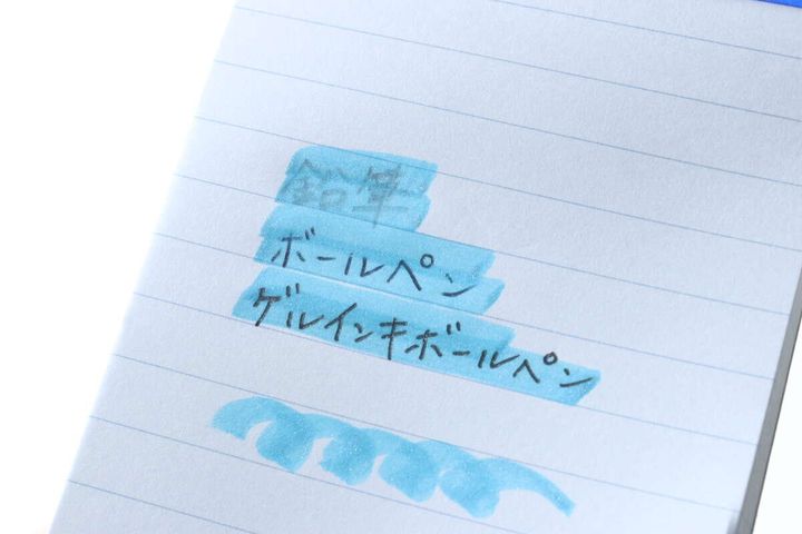 ボールペンで書かれた文字の上に青い蛍光ペンで線を引いた様子