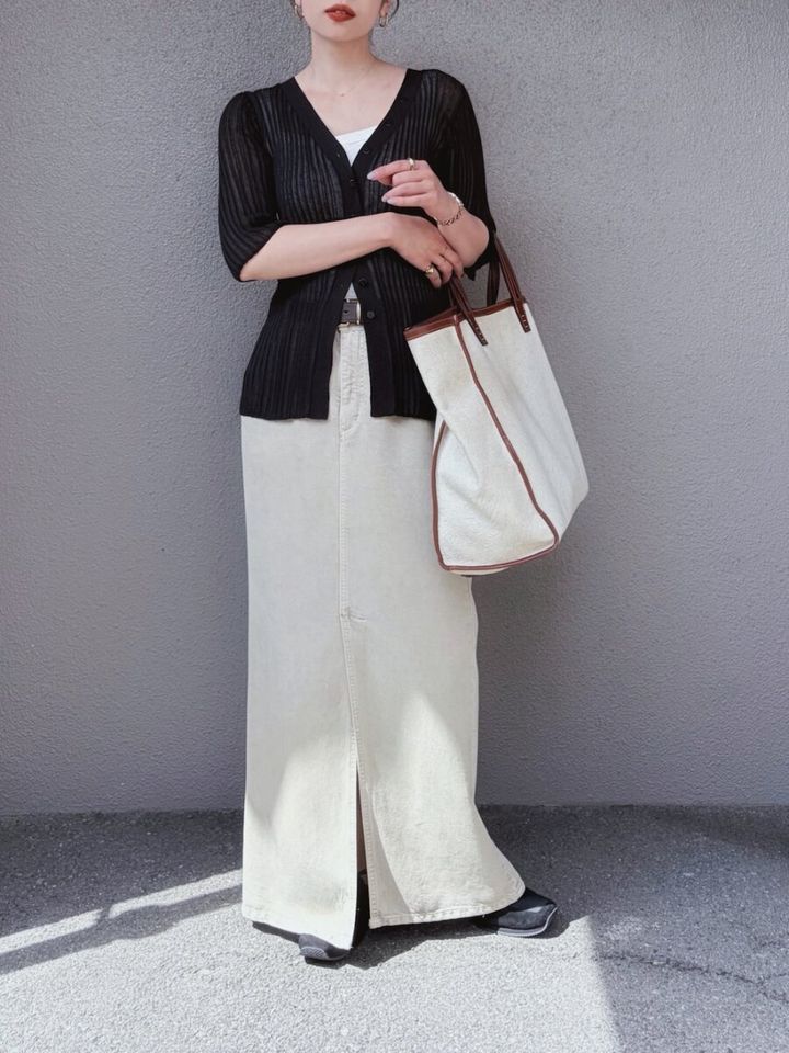 黒の透かし編みカーディガンと白のロングスカートでIラインを作る女性