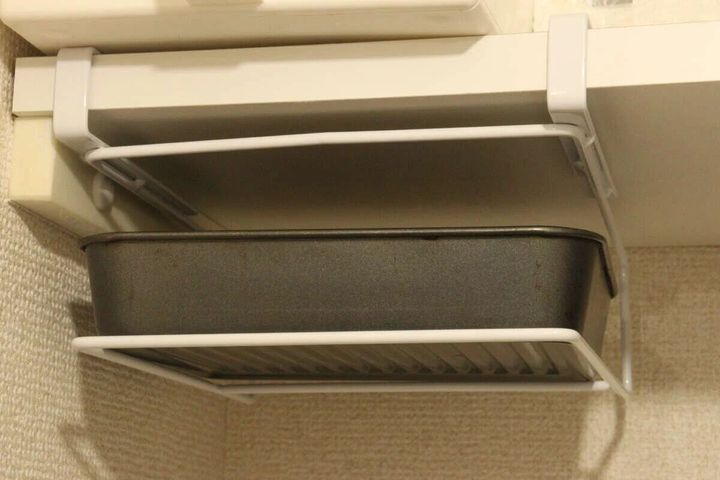 吊り戸棚下に設置されたラックにオーブン皿が収納されている