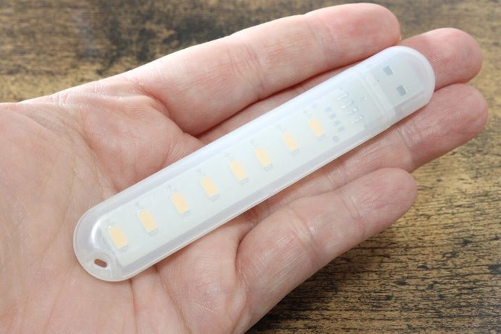 女性の手に乗せられた白いUSBスティックライト