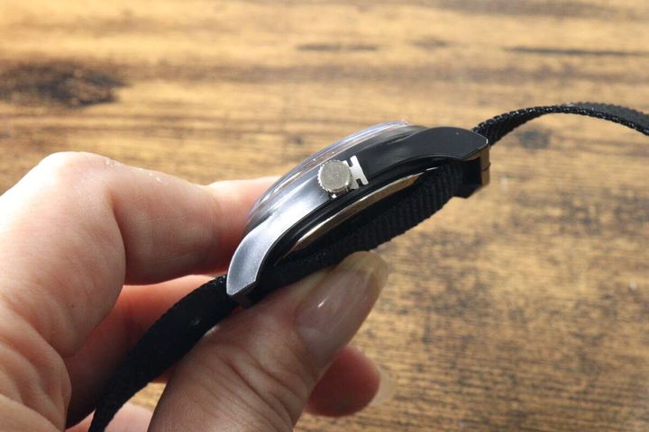 指でミリウォッチの側面を持ち、ケースの薄さを確認している