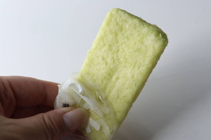 個包装から出しかけているメロン色のライスクラッカー