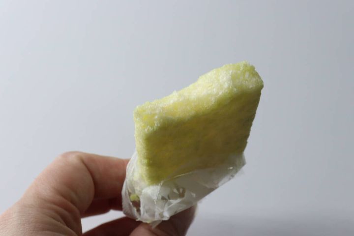 手で持たれたメロン色のライスクラッカーの断面