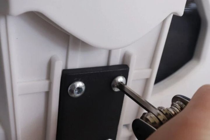 女性が家具のネジを六角レンチで締めている