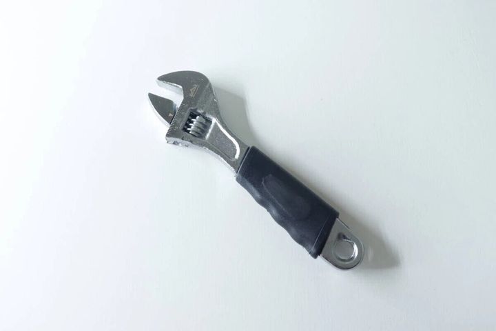 黒いグリップが付いたシルバーのモンキーレンチ