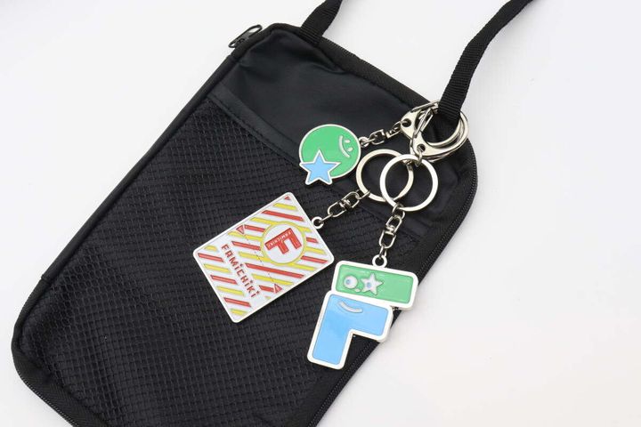 ファミチキとFロゴのキーホルダーが黒いバッグに付いている