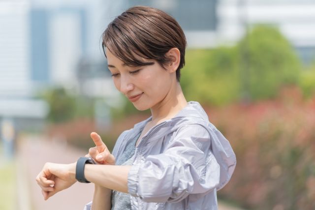 時計をチェックする女性 ランニング マラソン