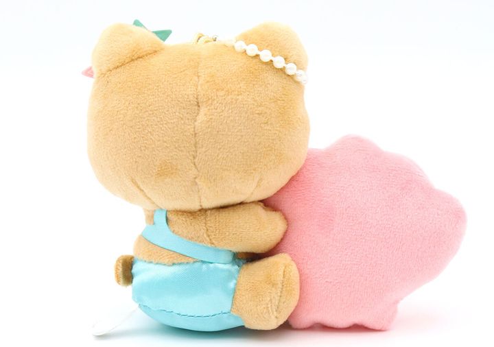 日焼けしたハローキティのぬいぐるみチャームがピンクの貝殻を抱えている背面