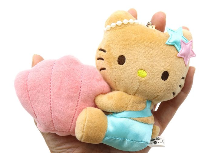 手のひらに日焼けしたハローキティのぬいぐるみチャームが乗せられている様子