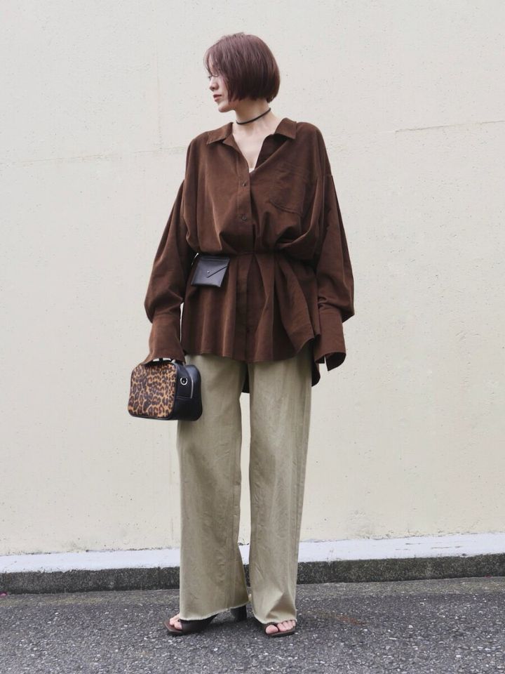 ブラウンのビッグシャツをウエストマークしワイドパンツを履く女性