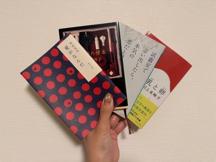 おすすめ小説『愛がなんだ』『薬指の標本』『試着室で思い出したら、本気の恋だと思う。』『乳と卵』の4冊を手に持った写真