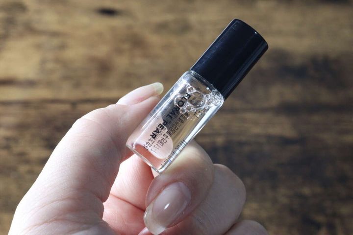 女性の指がセリアのロールオンフレグランスの小さなボトルを斜めに持っている