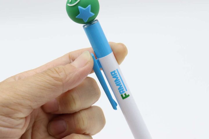 指でボールペンのクリップ部分を押している様子