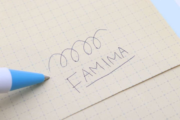 ボールペンで方眼紙に「FAMIMA」と書いている様子