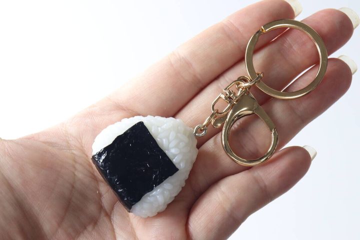 女性の手のひらに乗せられたおにぎりキーホルダー