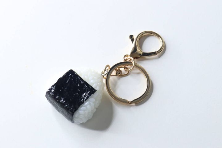 白い背景に置かれたおにぎり型のキーホルダー