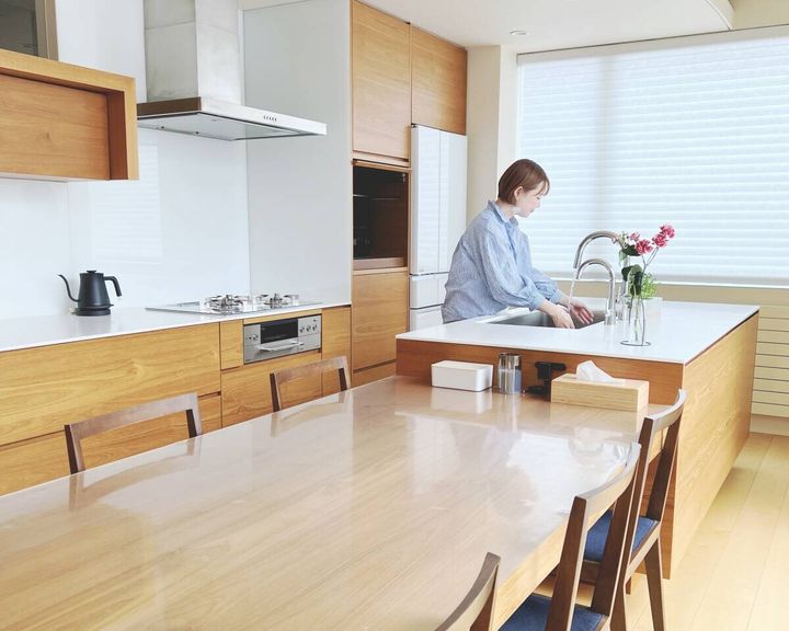 広々としたキッチンで女性がシンクで洗い物をしている様子