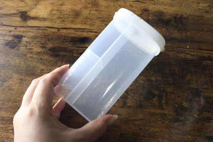 女性が手に持った透明なスティック出汁ケース。内部の仕切りが見える