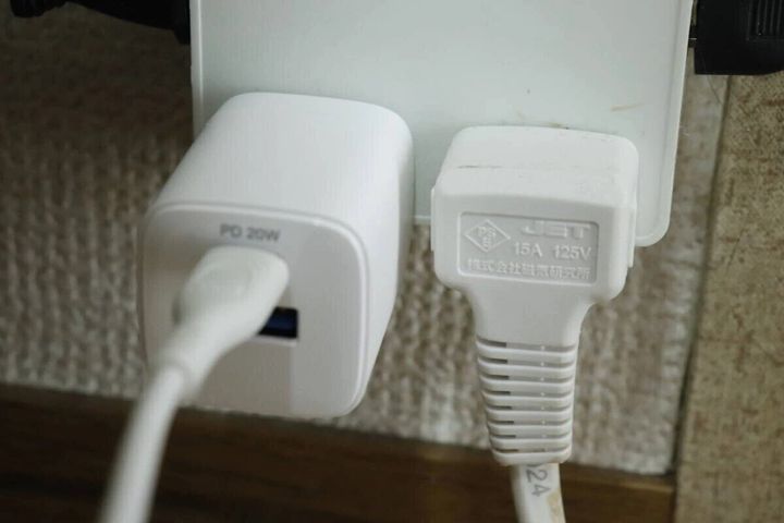 白いGaN USB充電器がコンセントに挿され充電している