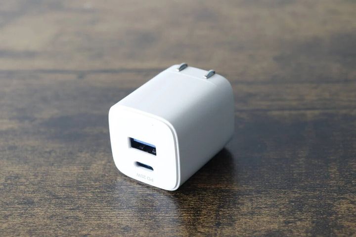 白いGaN USB充電器が木目調のテーブルに置かれている