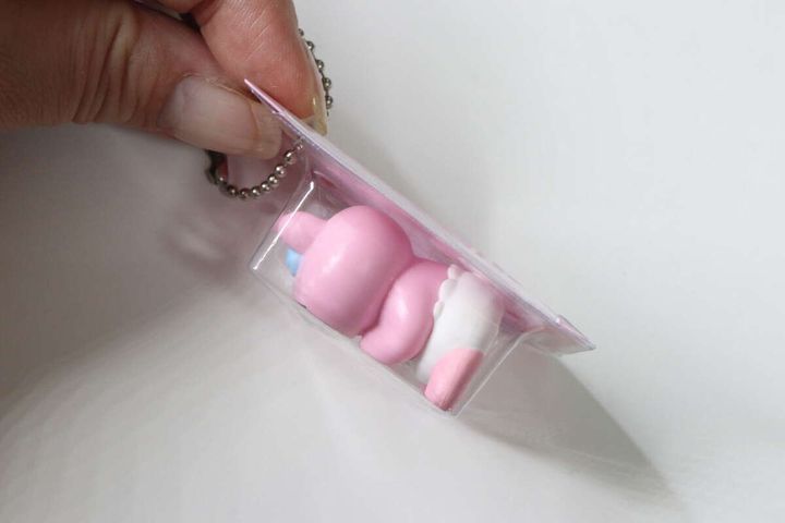 キーホルダーベースに入れたおぱんちゅうさぎのマスコットを指で持っている側面