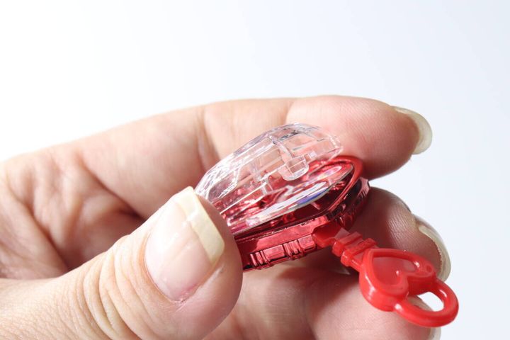 指でジュエルキーホルダーの蓋を鍵で開けようとしている様子