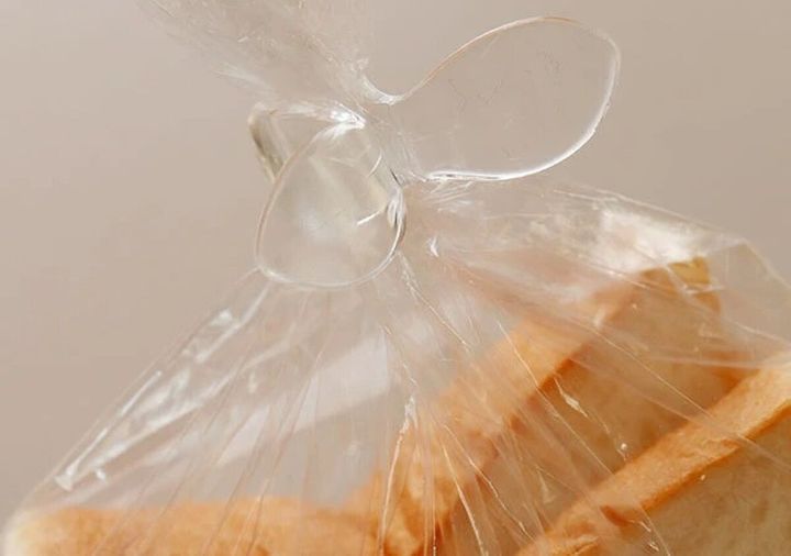 透明なウイングクリップで食パンの袋の口を留めている様子