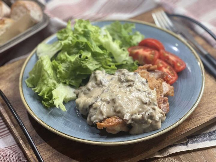 完成したチキンソテーきのこクリームソースとサラダが盛り付けられた青いお皿