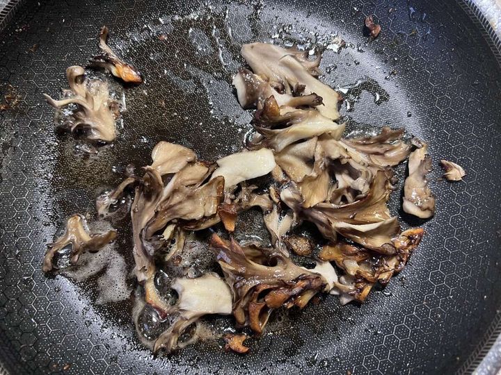 鶏肉を焼いた後のフライパンでほぐした舞茸を炒めている様子