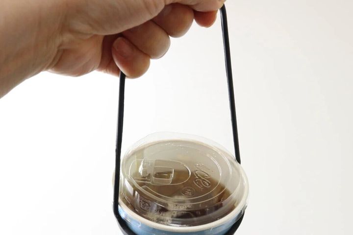 カップホルダーを装着したドリンクを片手で持っている