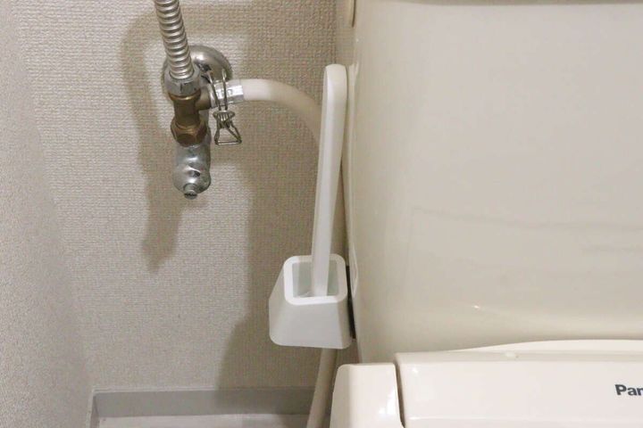 トイレタンク側面にマグネットで浮かせて収納されたトイレブラシ