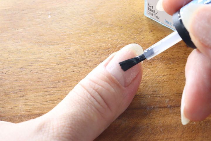 女性が自分の爪にダイソーのプレプライマーを塗布している様子