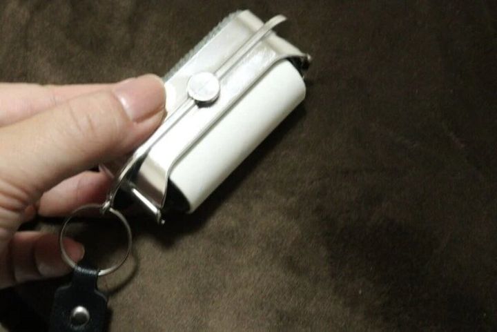 手で持ったほこり取りの粘着テープ部分で茶色い布を転がしている