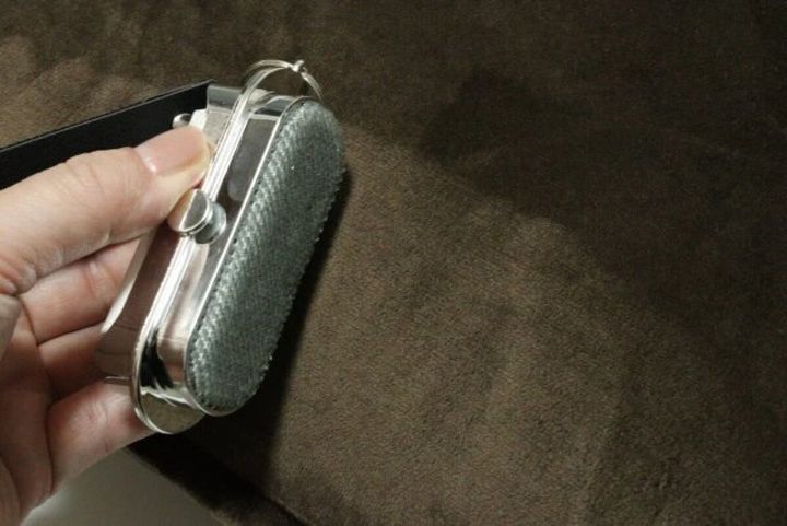 手で持ったほこり取りのブラシ部分で茶色い布をこすっている