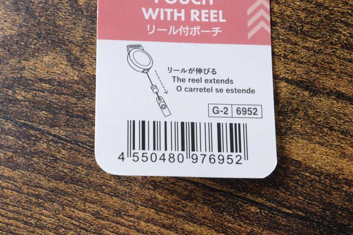 リール付ポーチの商品タグのバーコードと「リールが伸びる」の説明部分のアップ