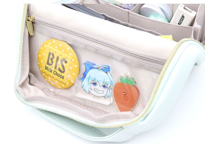 ポーチのクリアポケットに缶バッジとアクリルスタンドが入っている