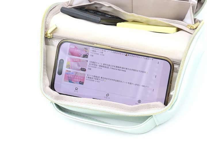 ポーチの背面のクリアポケットに立てたスマホで動画を再生している