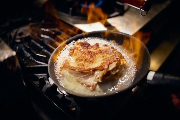 鶏肉を返し、酒でフランベする