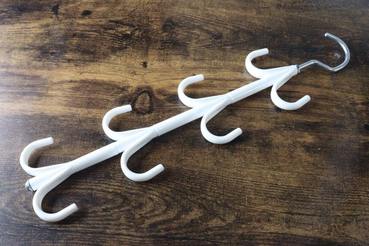 白い小物収納ハンガーがパッケージから出され、フックが複数付いた状態で置かれている
