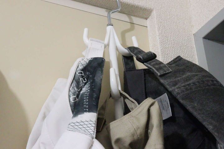 小物収納ハンガーにバッグや帽子が吊るされ、クローゼットのポールに掛けられている様子