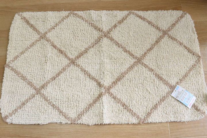 木目調の床に広げられたベージュのダイヤ柄フロアマット