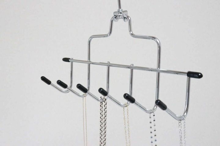 フックハンガーにネックレスが複数掛けられアクセサリー収納として使われている