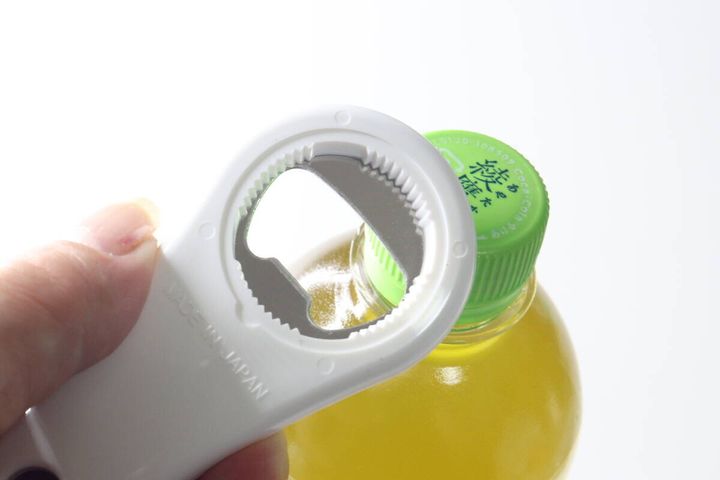 白いオープナーを緑色のペットボトルキャップに当てている