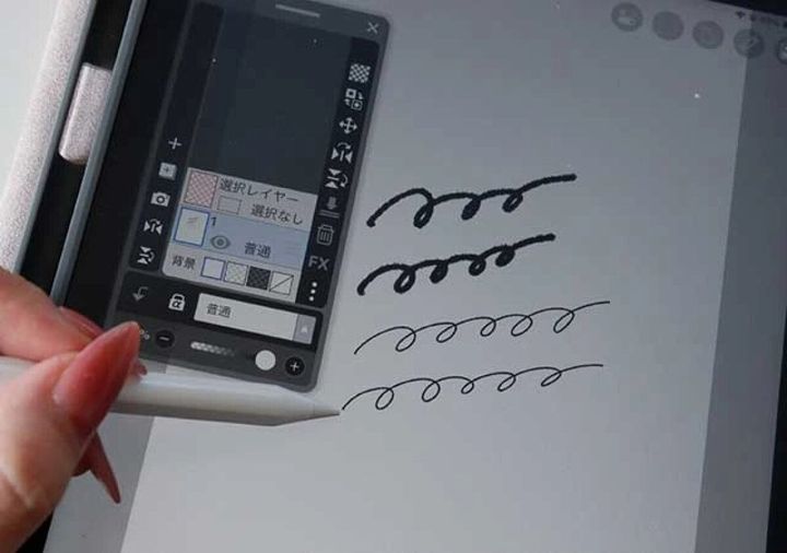 女性の手がタッチペンでiPadの画面に波線を描いている