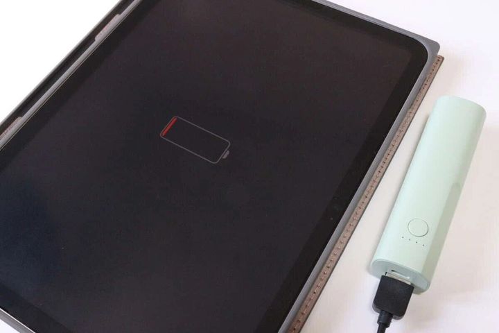 充電切れのiPadと、ミントグリーンのモバイルバッテリーがケーブルで繋がれている