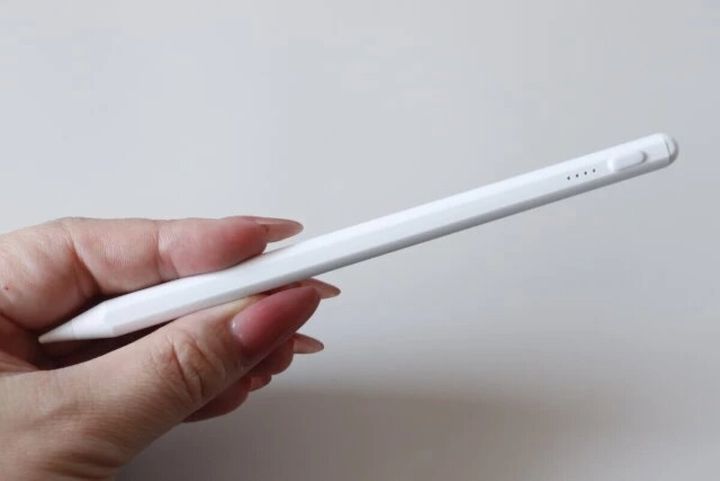女性の手が白いタッチペンを握っている