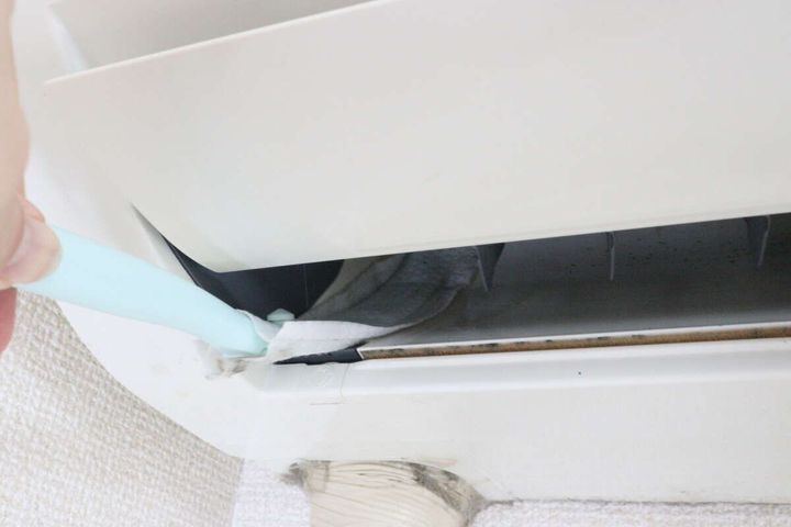 エアコン内部の吹き出し口をワイパーで拭いている様子